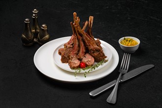 Grilled rack of lamb on a plate with spicy sauce