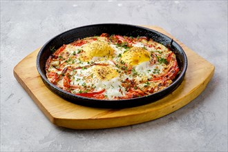 Eggs with bell pepper and tomato baked in oven in cast-iron skillet