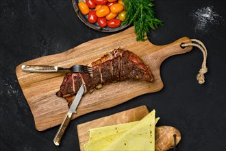 Top view of grilled lamb breast and flap on wooden cutting board
