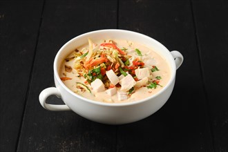 Creamy chicken soup puree with fried carrot and onion