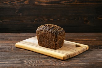 Fresh rye brown bread on wooden cutting board