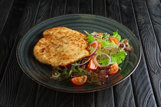 Schnitzel in breading with fresh vegetables and rings of red onion