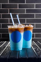 Concept of blue coffee cocktail. Plastic take away cup of blue ice drink