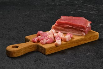 Raw pork belly on wooden cutting board
