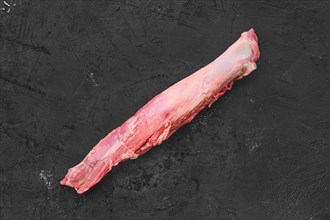 Top view of raw fresh pork fillet on black background