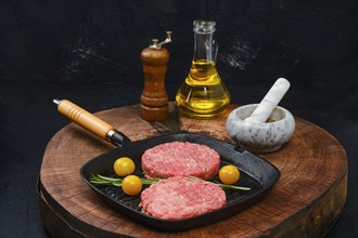 Raw beef burger cutlet on cast iron pan