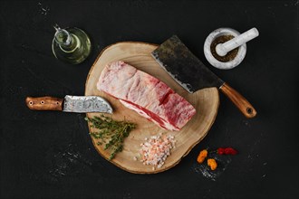 Overhead view of raw beef brisket on wooden cutting board