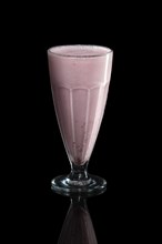 Glass of raspberry milk cocktail isolated on black