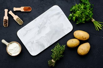 Top view of composition with marble serving board and ingredients for cooking