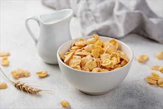 High angle breakfast corn flakes bowl with milk wheat
