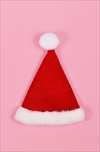 Single red Santa hat on pink background