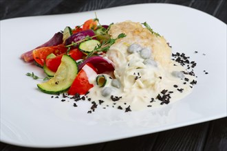 Fish fillet with grilled vegetables under cream sauce