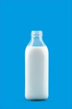 Open bottle of milk isolated on blue background