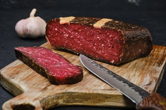 Rustic homemade cured beef ham on cutting board
