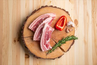 Raw fresh pork brisket slices on wooden cutting board