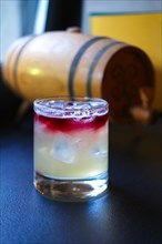 Soft focus photo of New york sour cocktail on bar counter. Image with shallow depth of field and contains a little noise due to poor lighting conditions