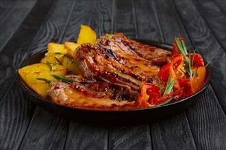 Fried meat on rib with potato and tomato