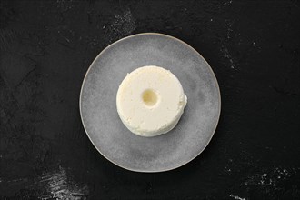 Top view of pressed cottage curd cheese on ceramic plate