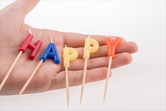 Color candles on sticks write the word happy