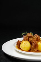 Closeup view of lamb stew with potato on a plate