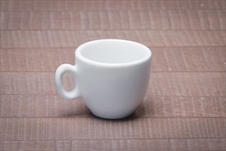 Clean and empty ceramic cup for espresso without saucer on wooden table