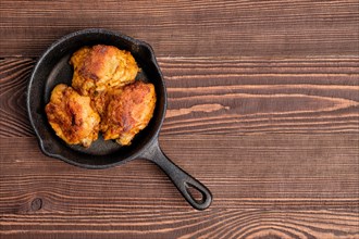 Top view of fried chicken thighs in cast iron skillet