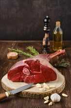 Raw fresh young beef leg on wooden background