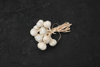 Overhead view of bunch of garlic on dark background