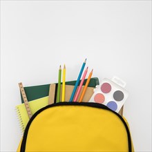 Open knapsack with school accessories