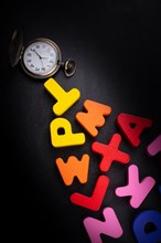 Pocket watch and colorful Letters of Alphabet made of wood