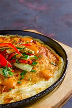 Vegetarian omelette with vegetables in cast iron pan