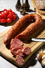Closeup view of smoked beef sausage rings on wooden cutting board on kitchen table