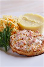 Fish cutlet with ham and melted cheese topping served with pickled cabbage and mashed potato