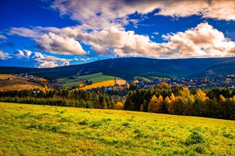 View over the village Oberwiesenthal in autumn in the Ore Mountains at sunset to the Keilberg in the Czech Republic