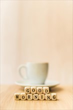 Close up good morning cubic blocks with cup coffee wooden surface