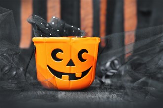Orange trick or treat Halloween basket with carved pumpkin face