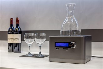Home electric decanter with wine glasses and bottles near it