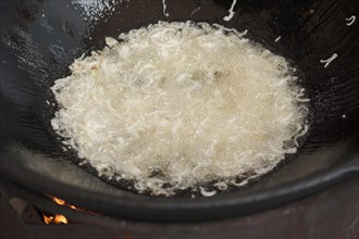 Frying onion in oil in cauldron. The making of pilaf