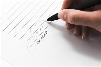 Hand signing document with pen