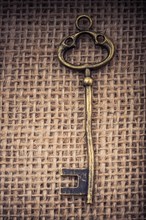 Retro styled golden color key on a linen canvas in view