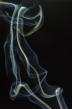 Trajectory of incense smoke in the air showing different shapes. France
