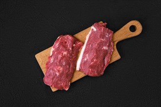 Top view of fresh lamb or veal loin steak on wooden cutting board