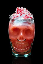 Halloween strawberry cocktail with whipped cream in skull glass isolated on black