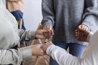 People holding hands group therapy session