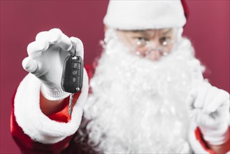 Santa claus holding car key in hand