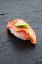 Sushi with seared salmon on slate plate