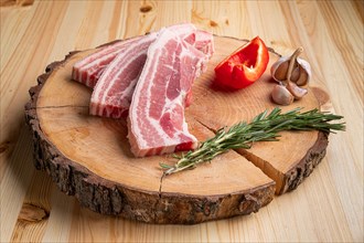 Raw fresh pork brisket slices on wooden cutting board