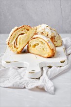 Cross section of croissant with caramel and peanut shavings on bright background