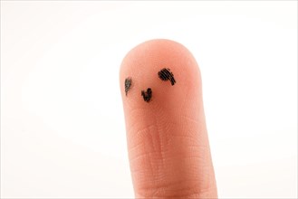 Black dots forming a face on the fingertip