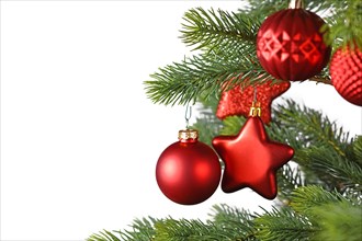 Red star and ball shaped Christmas baubles on decorated Christmas tree on side of white background with copy space